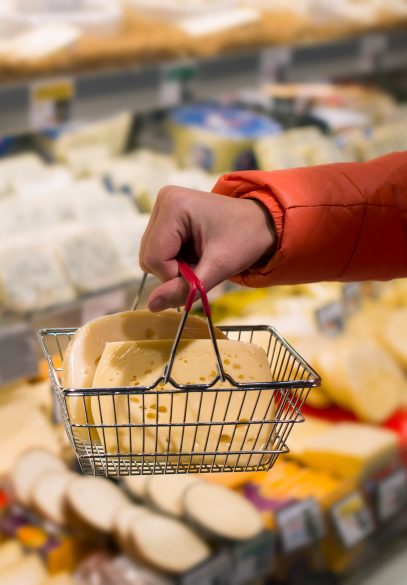 Handing holding basket of cheese